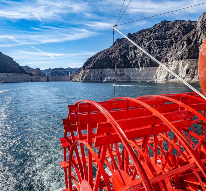 Boat on water infront of dam on Lake Mead. 